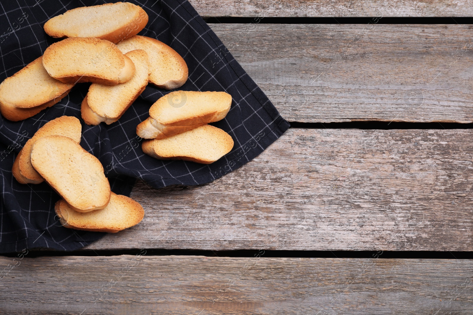 Photo of Tasty hard chuck crackers on wooden table, flat lay. Space for text