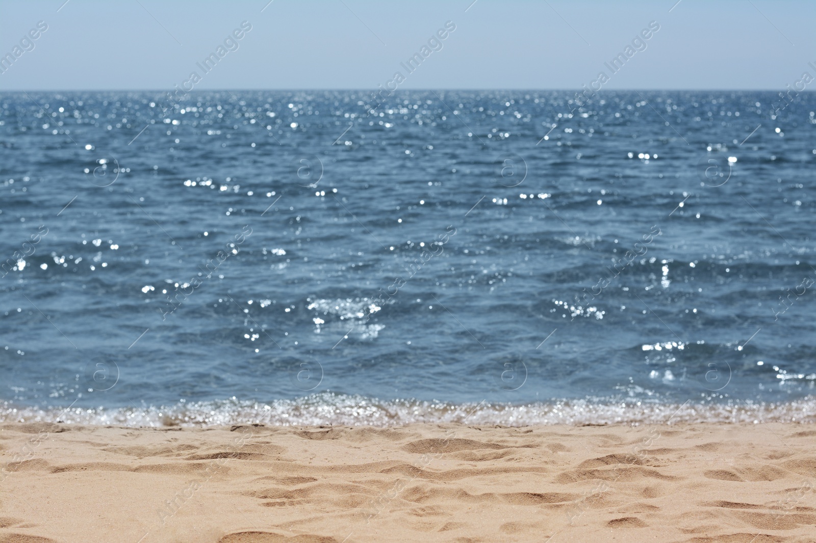 Photo of Picturesque view of sandy beach near sea on sunny day