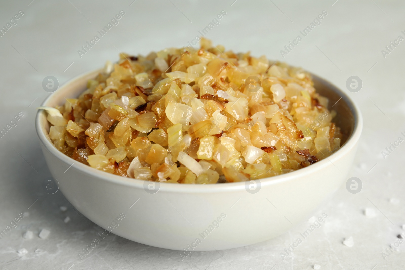 Photo of Tasty fried onion on grey marble table, closeup