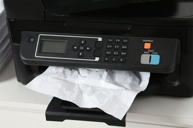 Photo of Modern printer with crumpled sheet of paper on white table, closeup