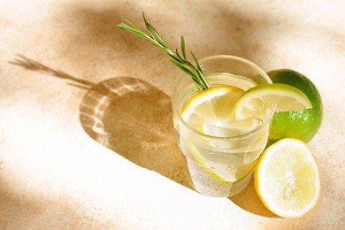 Photo of Tasty refreshing lemonade and ingredients on light table, space for text. Summer drink