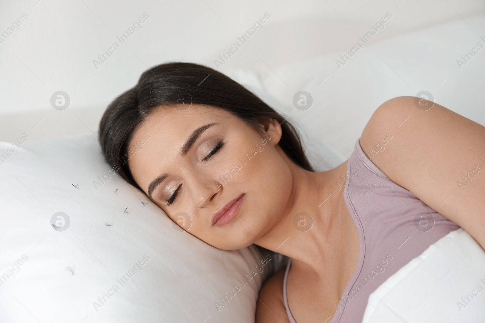 Photo of Young woman with eyelash loss problem sleeping in bed