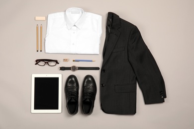 School uniform for boy and tablet on grey background, top view