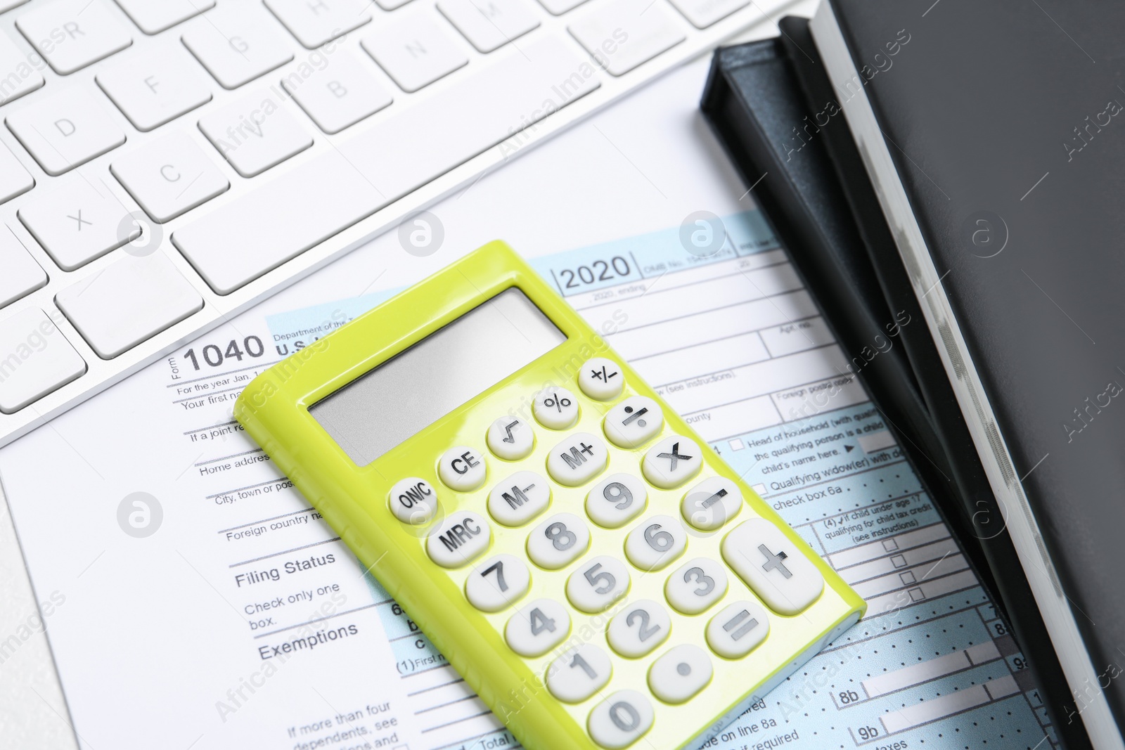 Photo of Calculator, document and notebooks on white table, closeup. Tax accounting