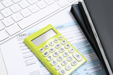 Photo of Calculator, document and notebooks on white table, closeup. Tax accounting