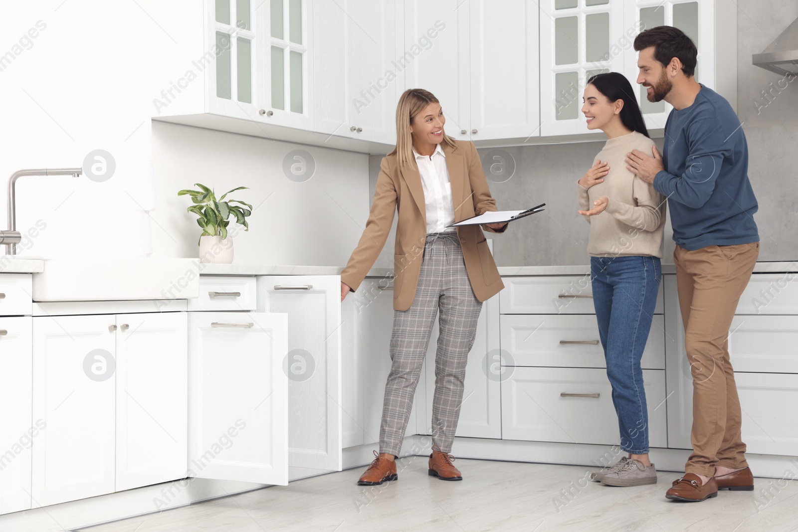 Photo of Real estate agent showing new apartment to couple