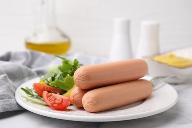 Delicious boiled sausages with salad on table