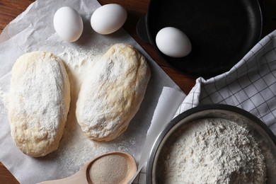 Photo of Raw dough, eggs and flour on wooden table, flat lay. Cooking ciabatta
