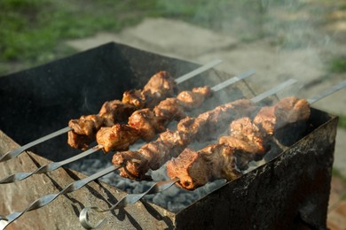 Photo of Cooking delicious meat on metal brazier outdoors