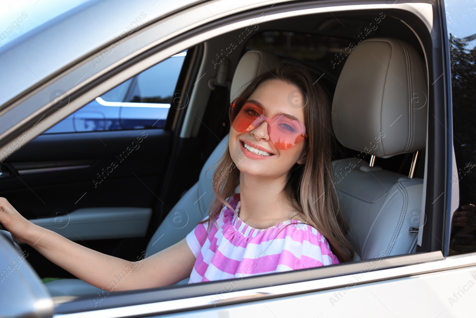 Photo of Happy woman with heart shaped glasses in car