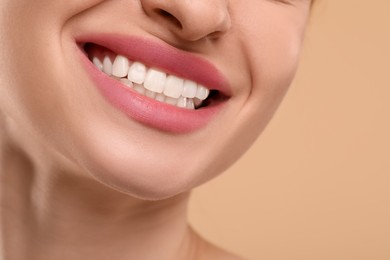 Photo of Woman with clean teeth smiling on beige background, closeup. Space for text