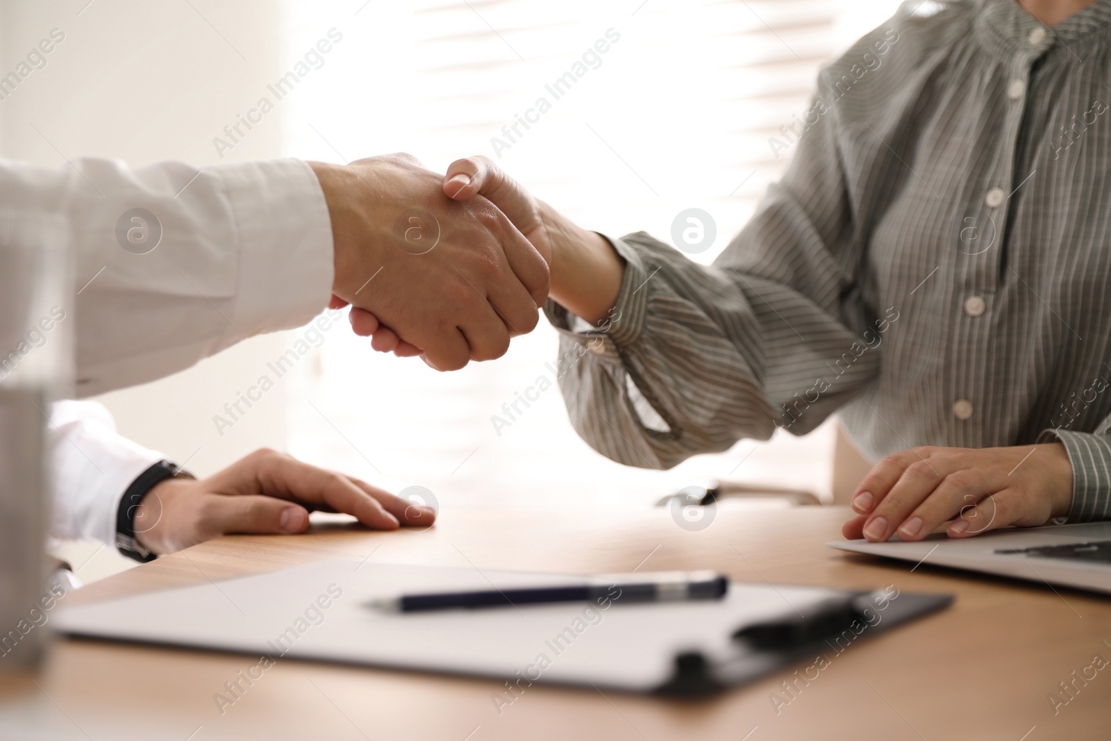 Photo of Business people shaking hands in office, closeup