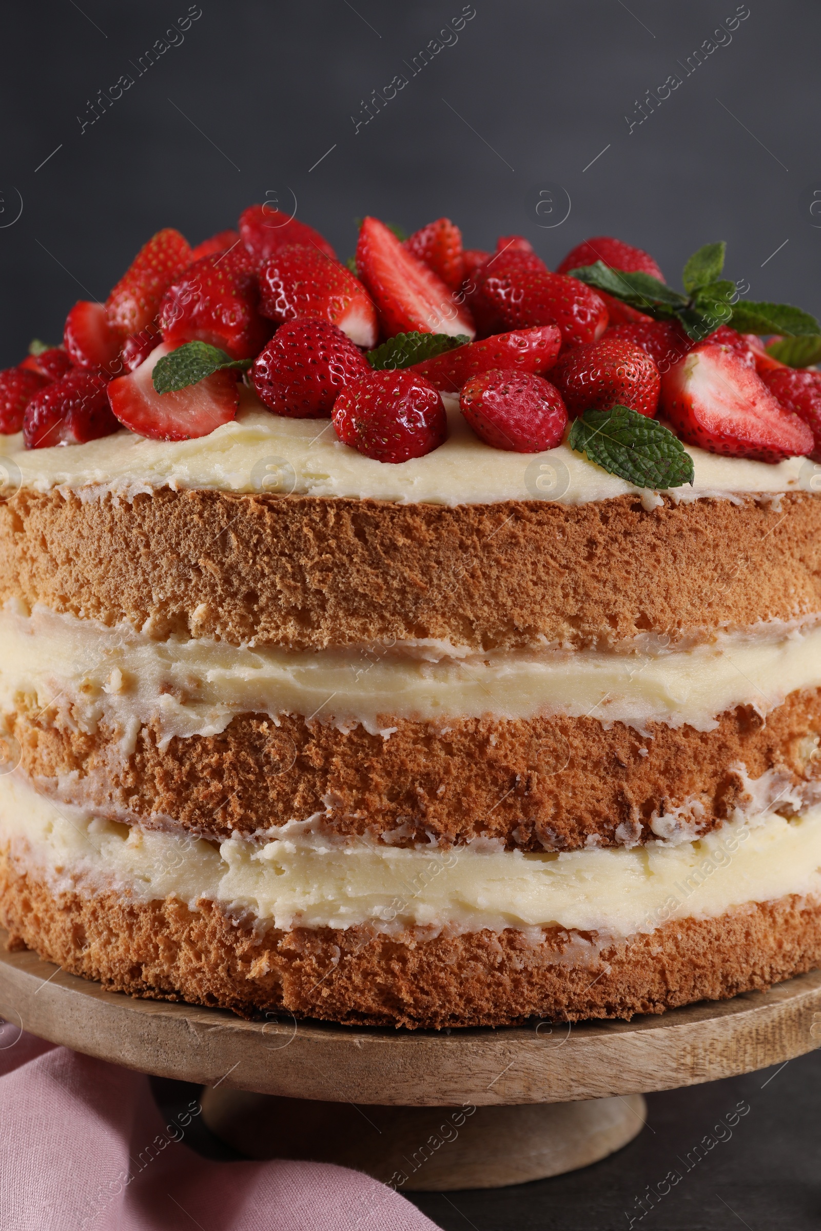 Photo of Tasty cake with fresh strawberries and mint on table, closeup