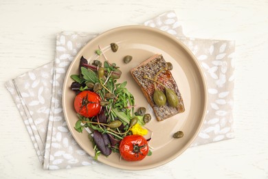 Photo of Tasty salmon with salad and capers on white wooden table, top view.