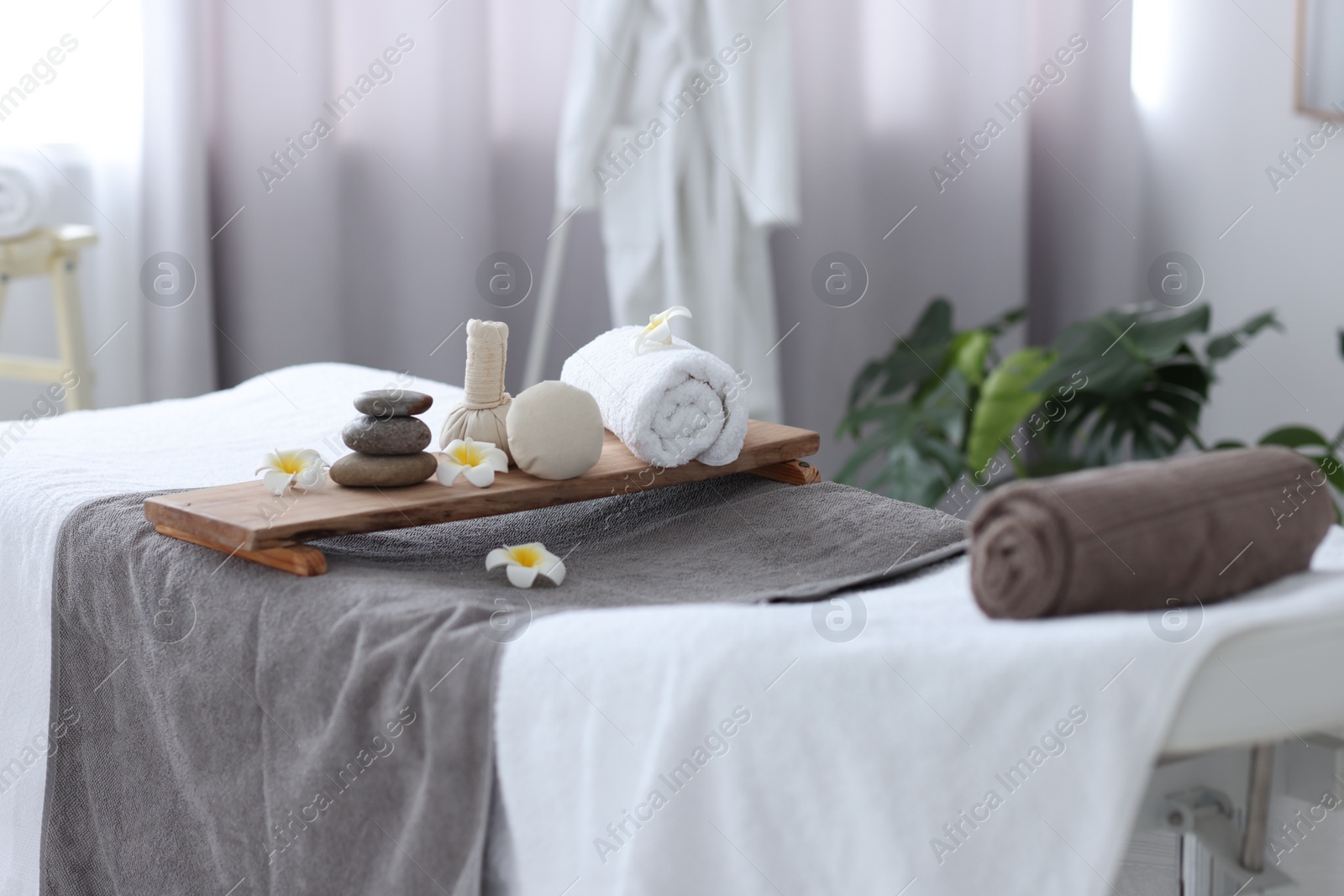 Photo of Rolled towel and spa products on massage table in recreational center