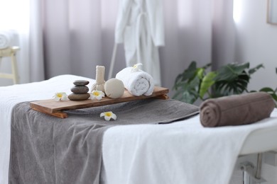 Rolled towel and spa products on massage table in recreational center