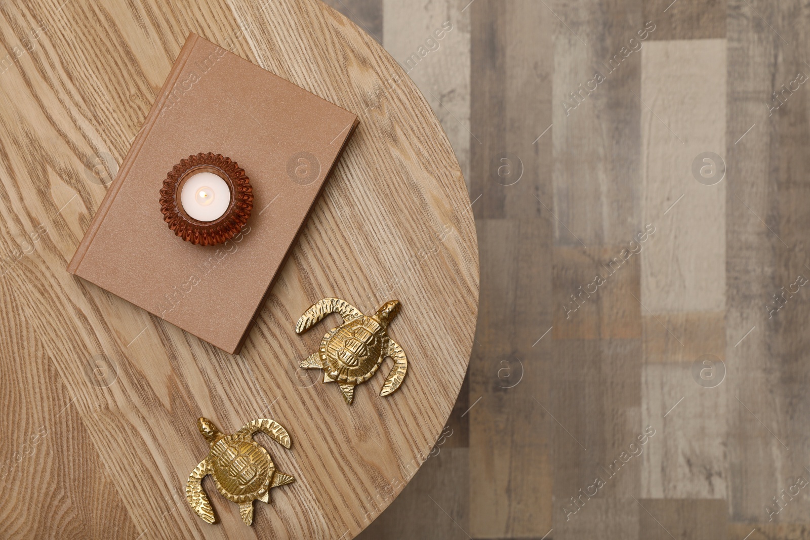 Photo of Book, candle and decor on round wooden table indoors, top view. Space for text