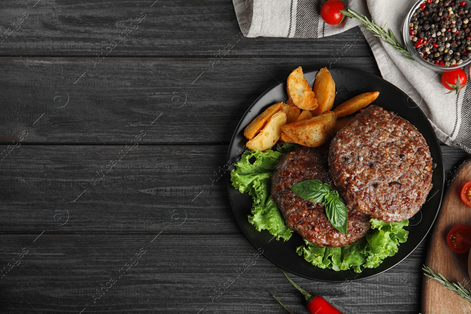 Photo of Flat lay composition with grilled meat cutlets for burger on black wooden table. Space for text