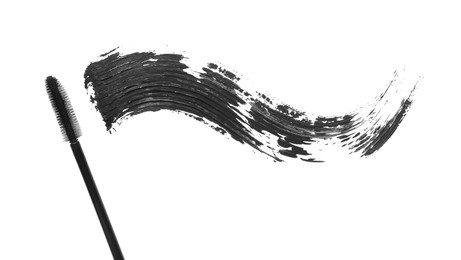 Photo of Smear of mascara and applicator isolated on white, top view