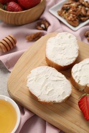 Delicious bruschettas with ricotta cheese, strawberries, walnuts and honey on table, above view