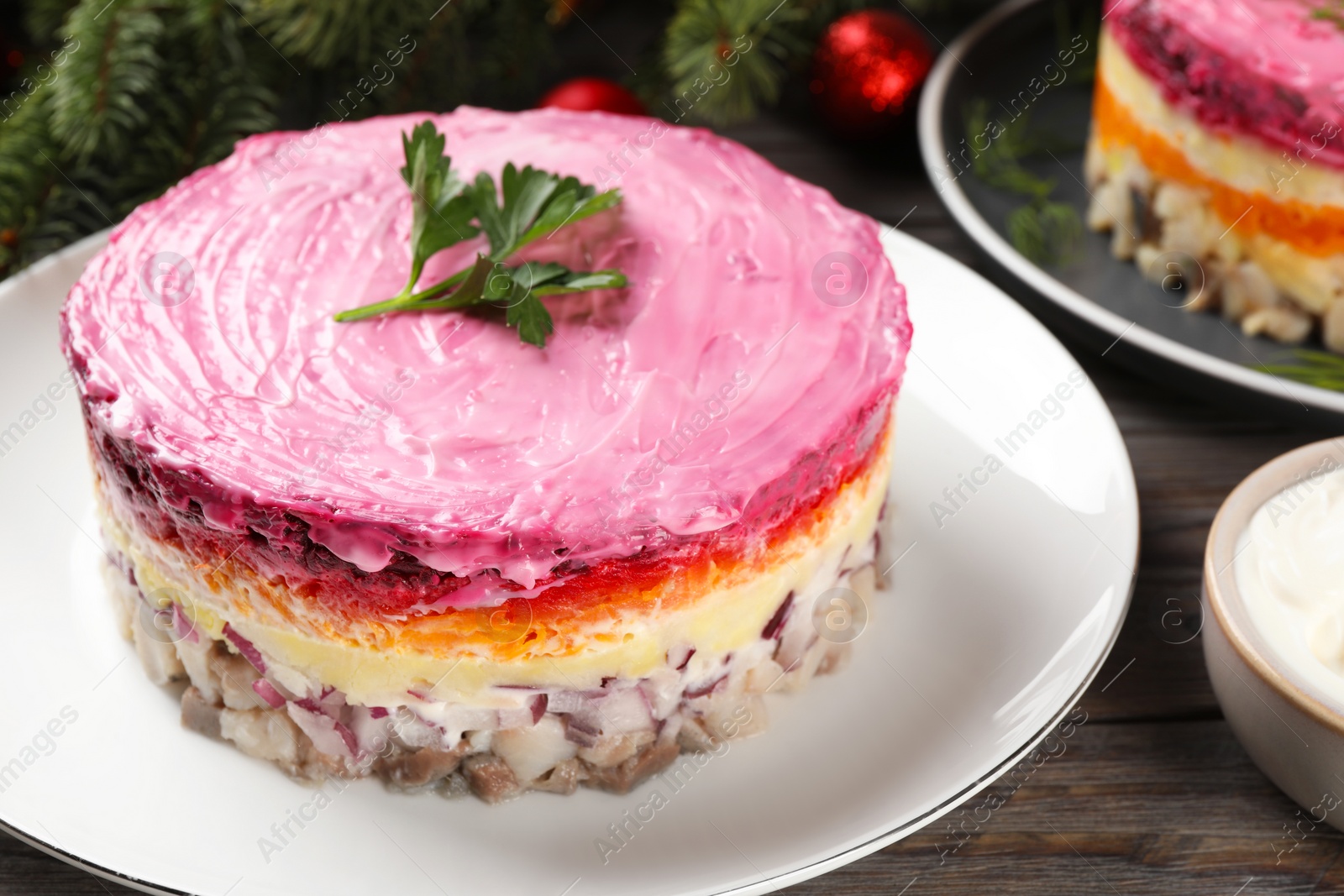 Photo of Herring under fur coat salad on wooden table, closeup. Traditional Russian dish