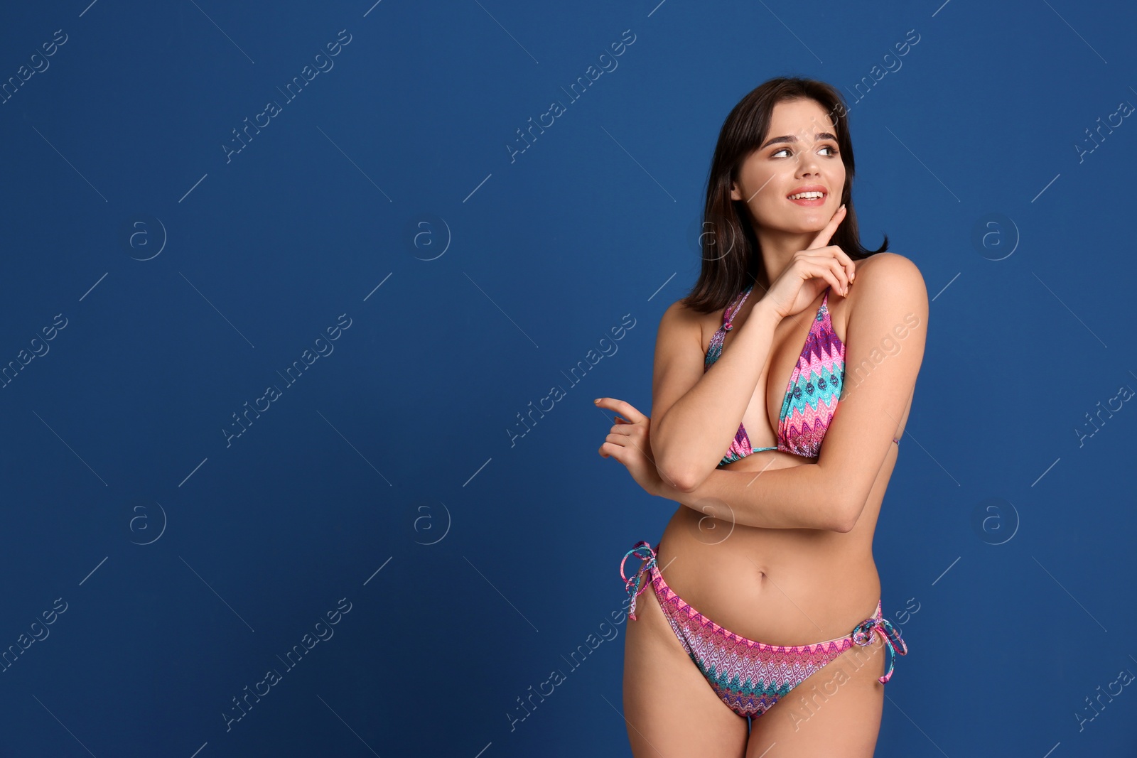 Photo of Beautiful young woman wearing bikini on blue background. Space for text