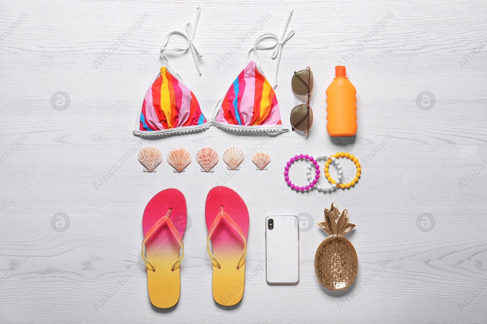 Photo of Flat lay composition with smartphone and beach objects on wooden background