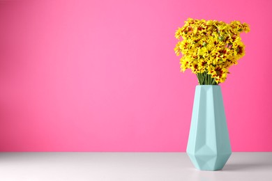 Vase with beautiful chrysanthemum flowers on white table. Space for text