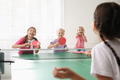 Photo of Cute happy children playing ping pong indoors