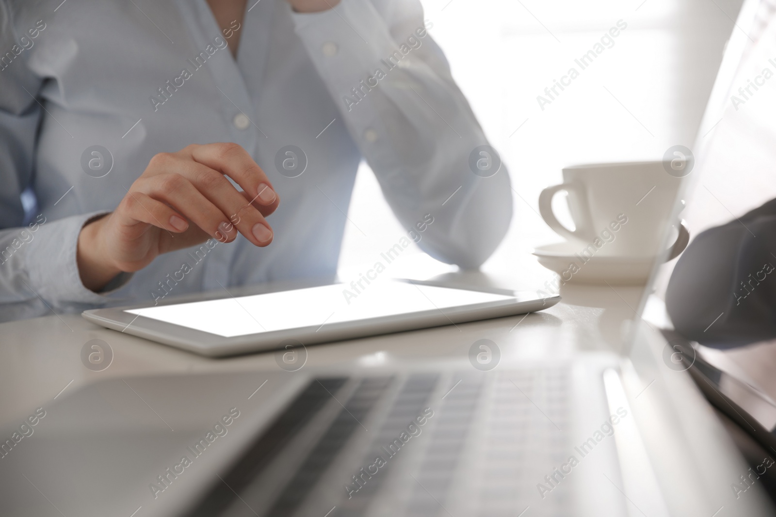 Photo of Businesswoman working with modern tablet at table in office, closeup