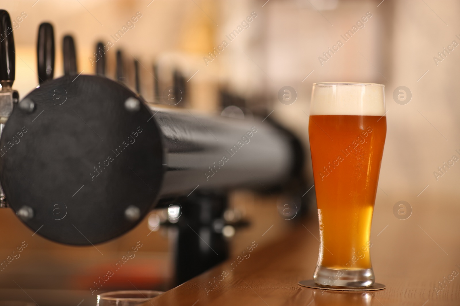 Photo of Glass of cold tasty beer on bar counter, space for text