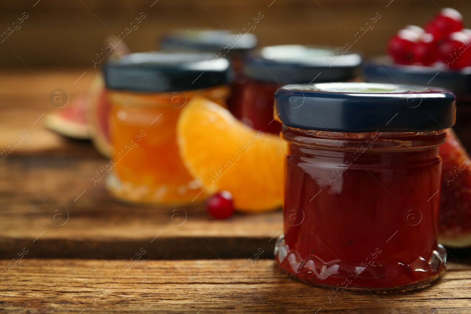 Photo of Jar of jam on wooden table, space for text