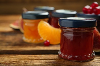 Jar of jam on wooden table, space for text