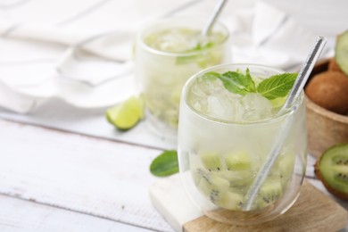 Photo of Refreshing drink with kiwi and mint on white table, closeup. Space for text