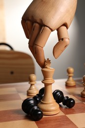 Photo of Robot moving chess piece on board, closeup. Wooden hand representing artificial intelligence