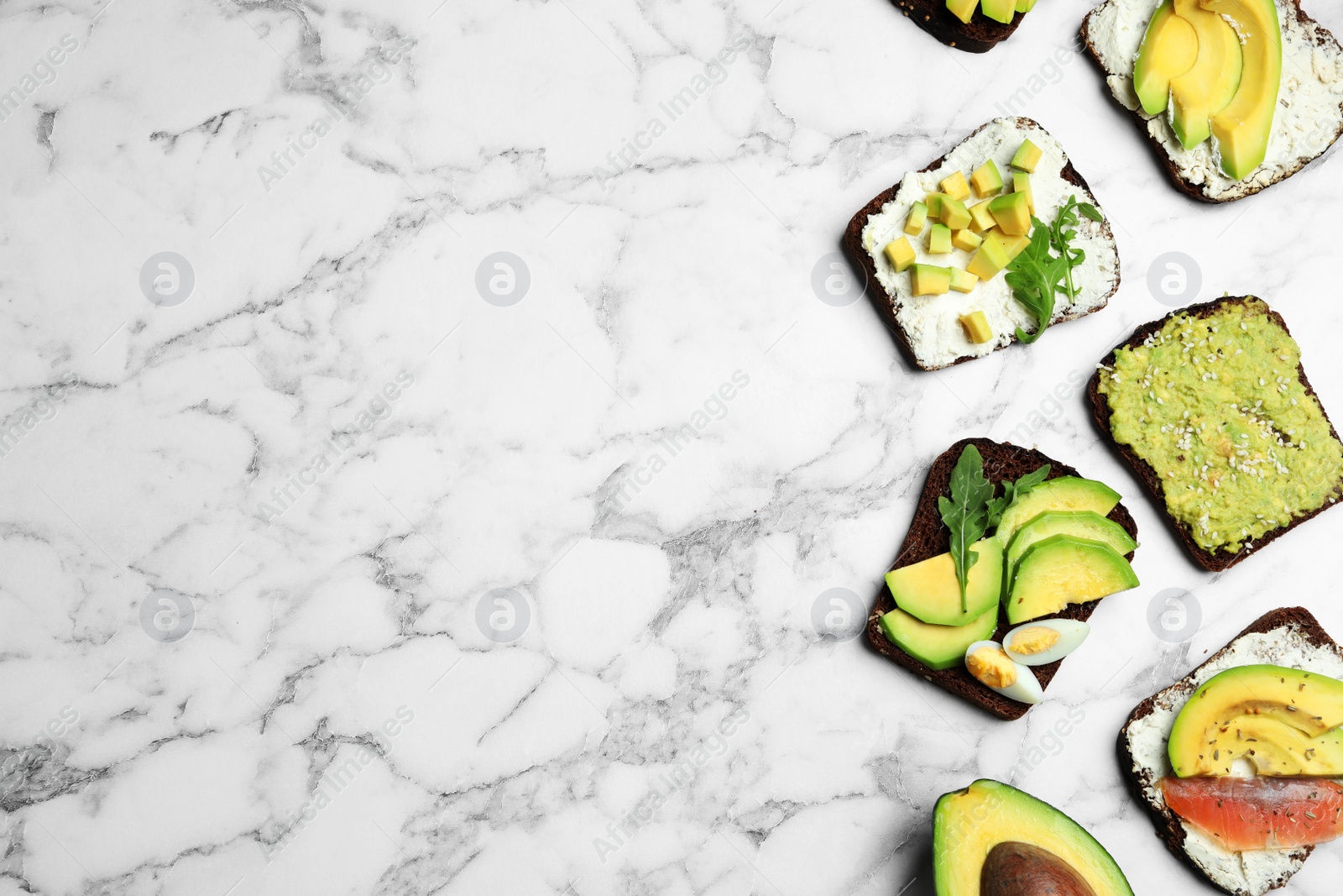 Photo of Delicious avocado sandwiches on white marble table, flat lay. Space for text