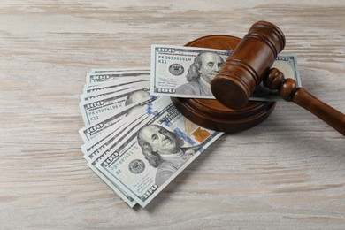 Judge's gavel and money on wooden table