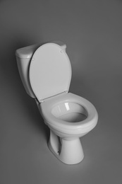 Photo of New ceramic toilet bowl on grey background