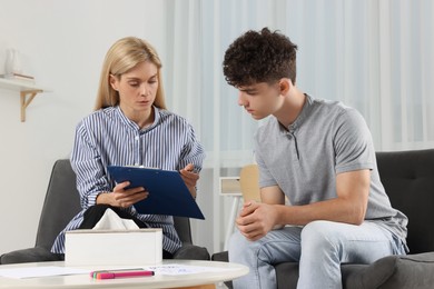 Photo of Psychologist working with teenage boy in office. Teenager problems