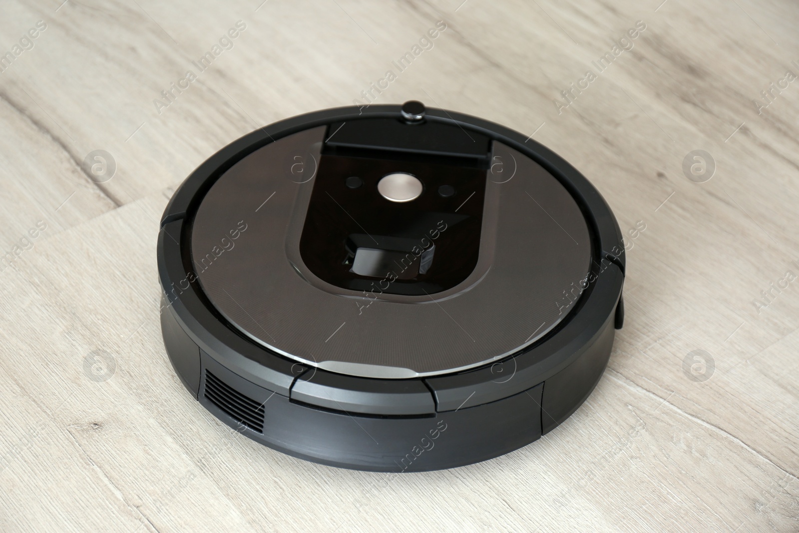 Photo of Modern robotic vacuum cleaner on wooden floor