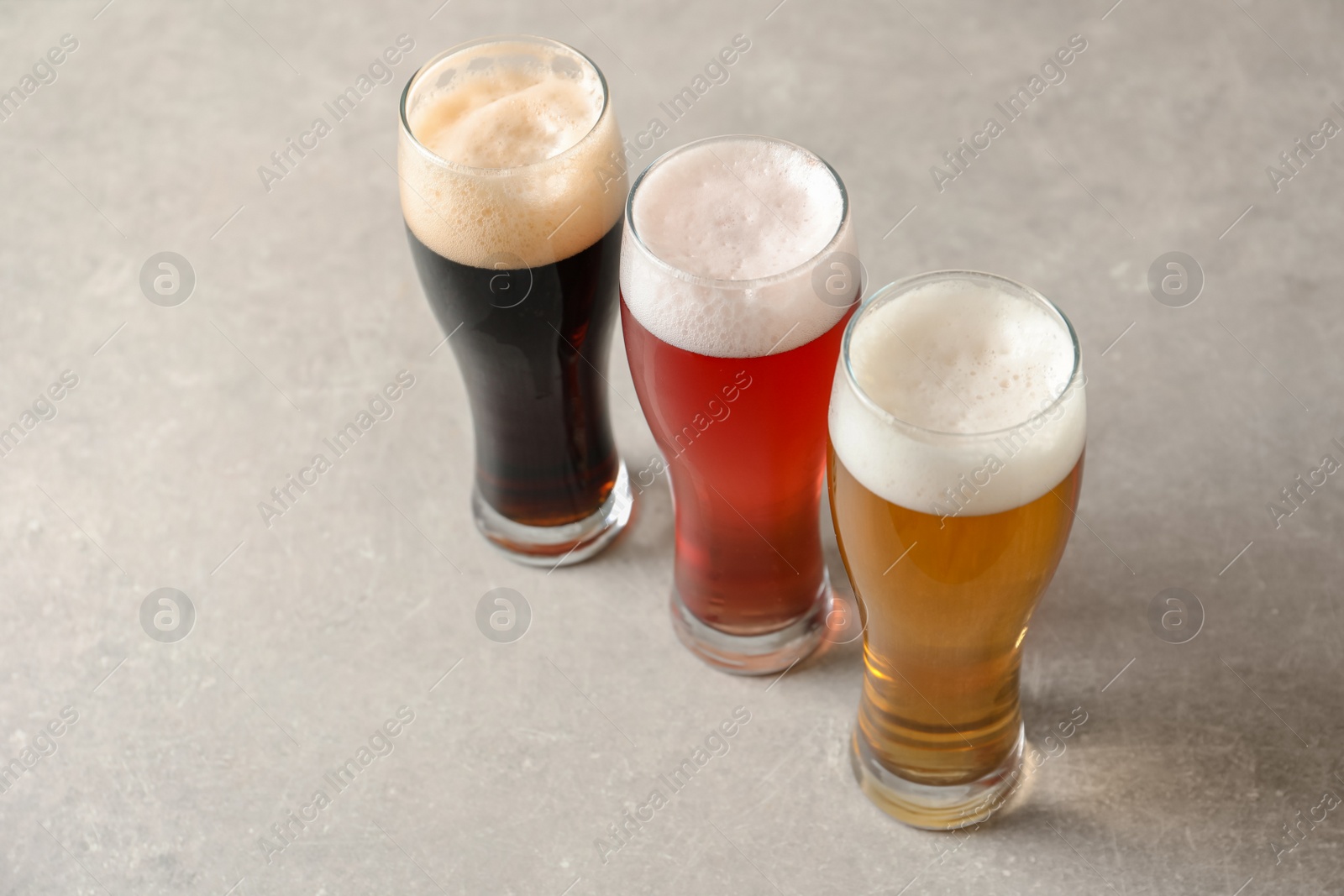 Photo of Glasses with different types of cold tasty beer on table