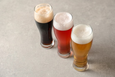 Glasses with different types of cold tasty beer on table