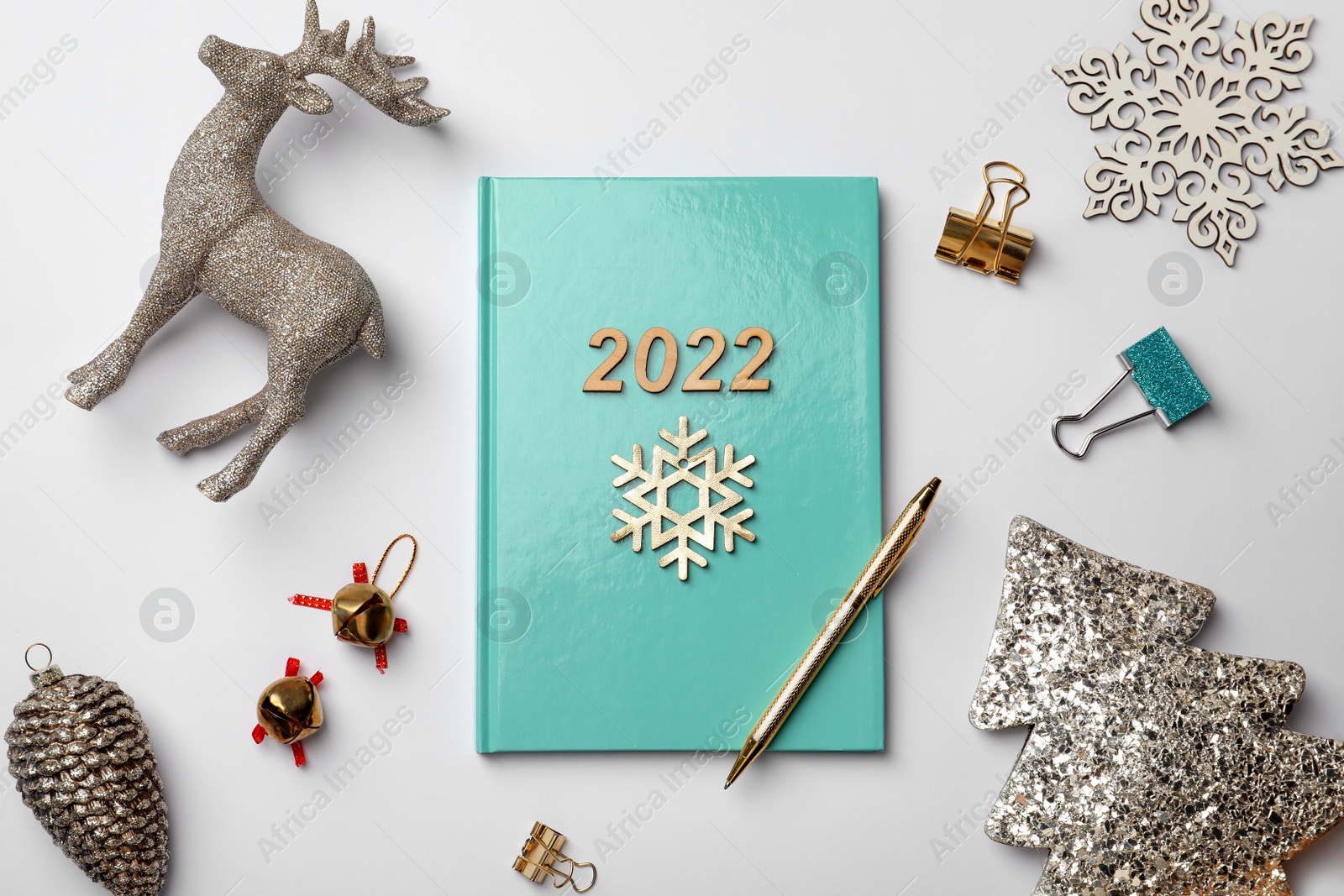 Photo of Turquoise planner and Christmas decor on white background, flat lay. 2022 New Year aims