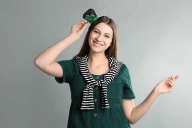 Photo of Happy woman in St Patrick's Day outfit on light grey background