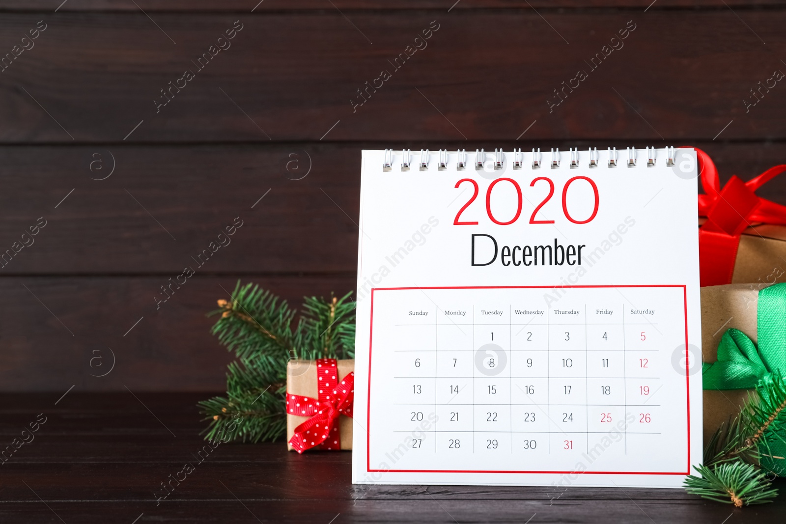 Photo of Flip calendar and Christmas decor on brown wooden table. Holiday countdown