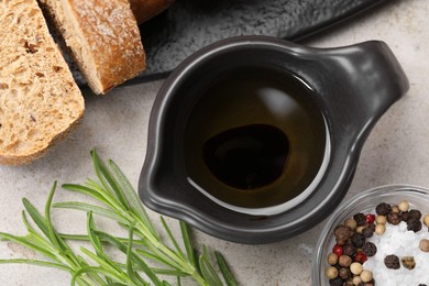 Photo of Saucepan of organic balsamic vinegar with oil, spices and bread slices on beige table, flat lay