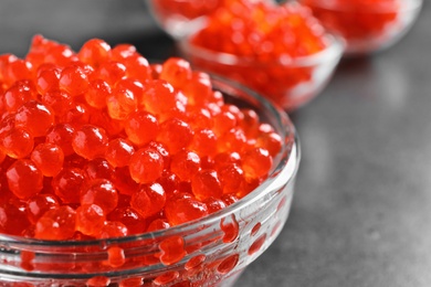 Glass bowl with delicious red caviar on table, closeup