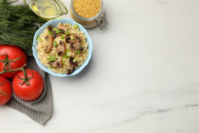 Delicious bulgur with mushrooms, green onion and other products on white marble table, flat lay. Space for text