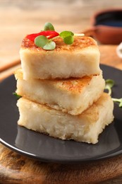 Photo of Delicious turnip cake with microgreens on wooden table, closeup