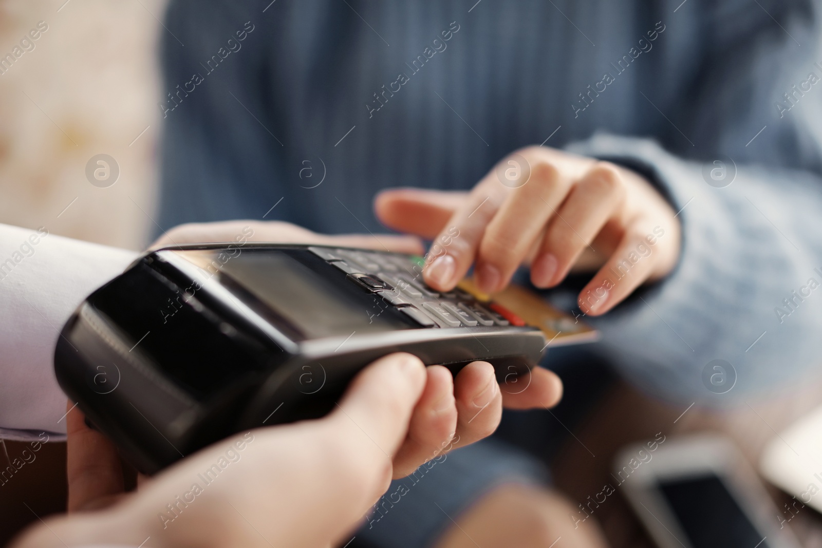 Photo of Woman with credit card using payment terminal at restaurant, closeup